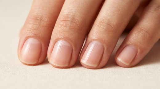 Unhas naturais com estrias verticais finas sobre linho creme